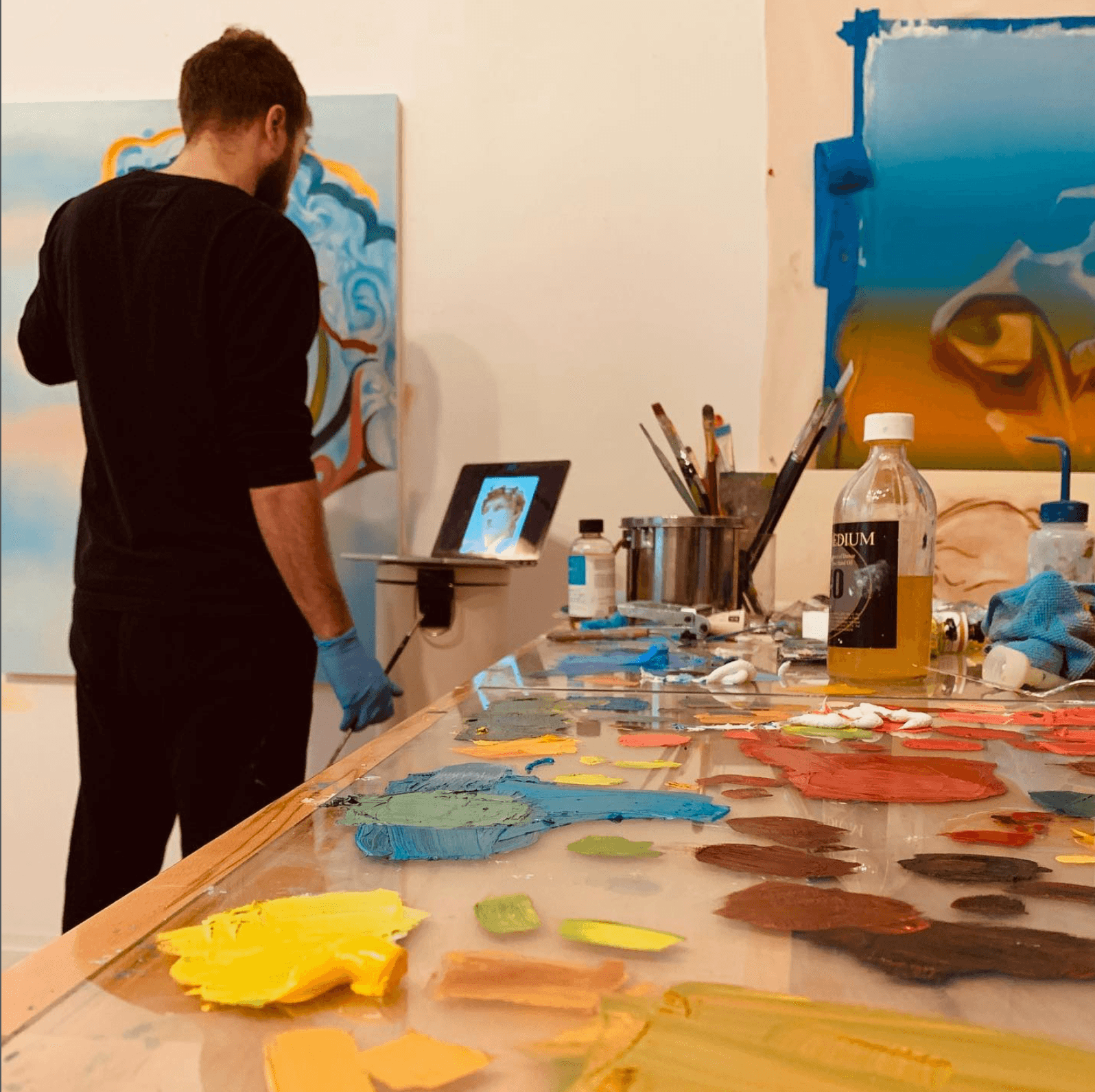 Julian Potulicki painting at the easel in his studio.